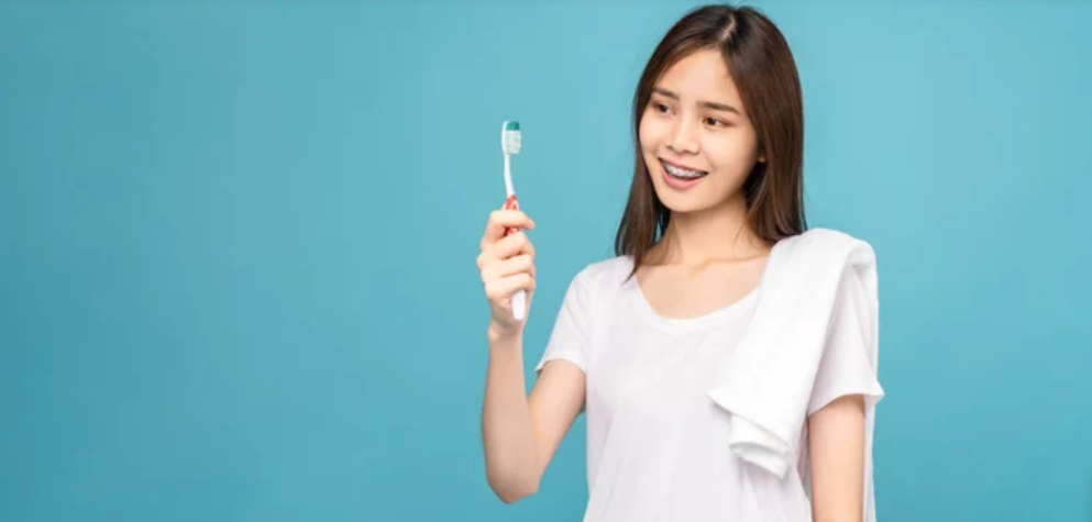 a girl with braces holding a toothbrush